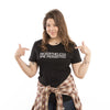 A woman pointing to the feminist text NEVERTHELESS SHE PERSISTED printed on her black t-shirt.