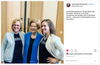Elizabeth Warren stands between two women wearing black Nevertheless She Persisted feminist t-shirts.