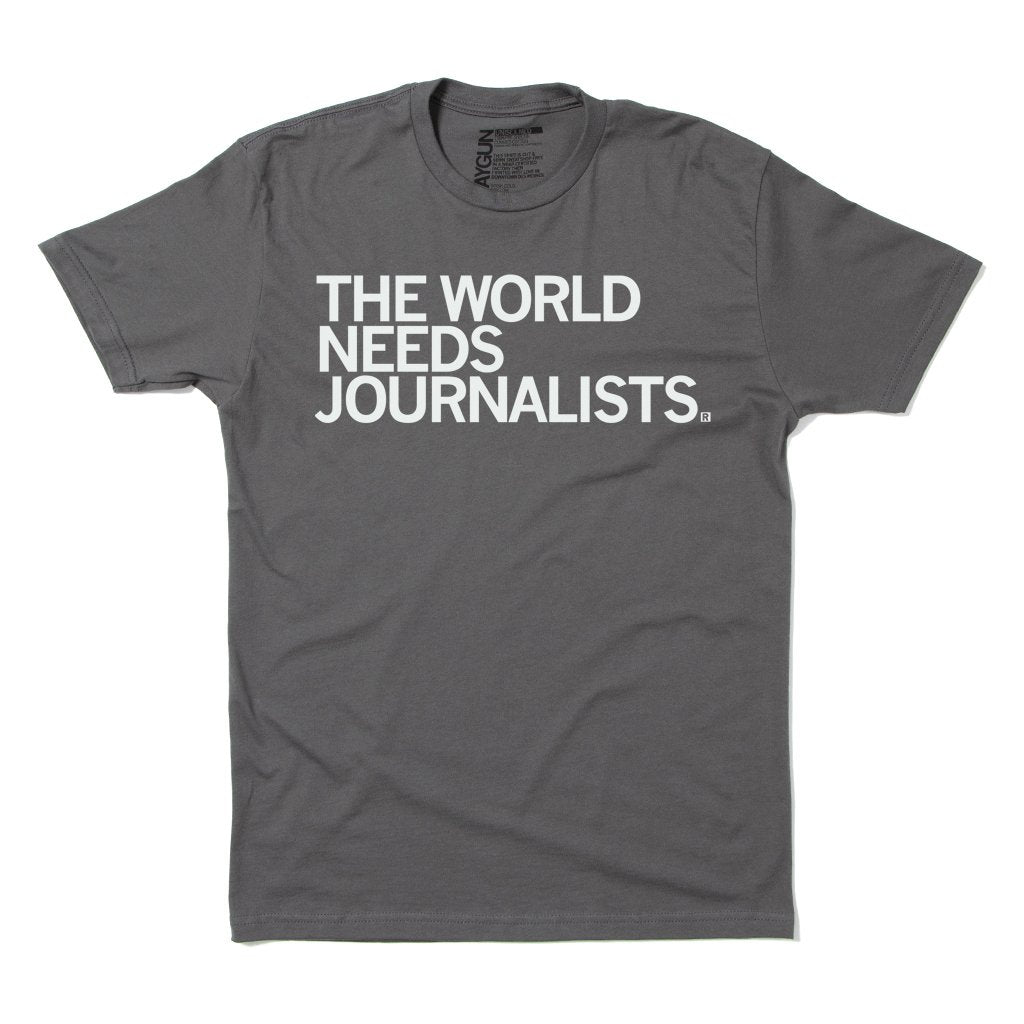 Gray crew-neck RAYGUN t-shirt with the text THE WORLD NEEDS JOURNALISTS. printed in white on the chest.