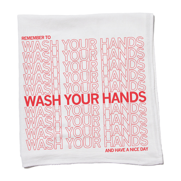White flour sack kitchen towel featuring the text Remember to wash your hands repeated in scarlet red, with one line in bold, and ending with And have a nice day.