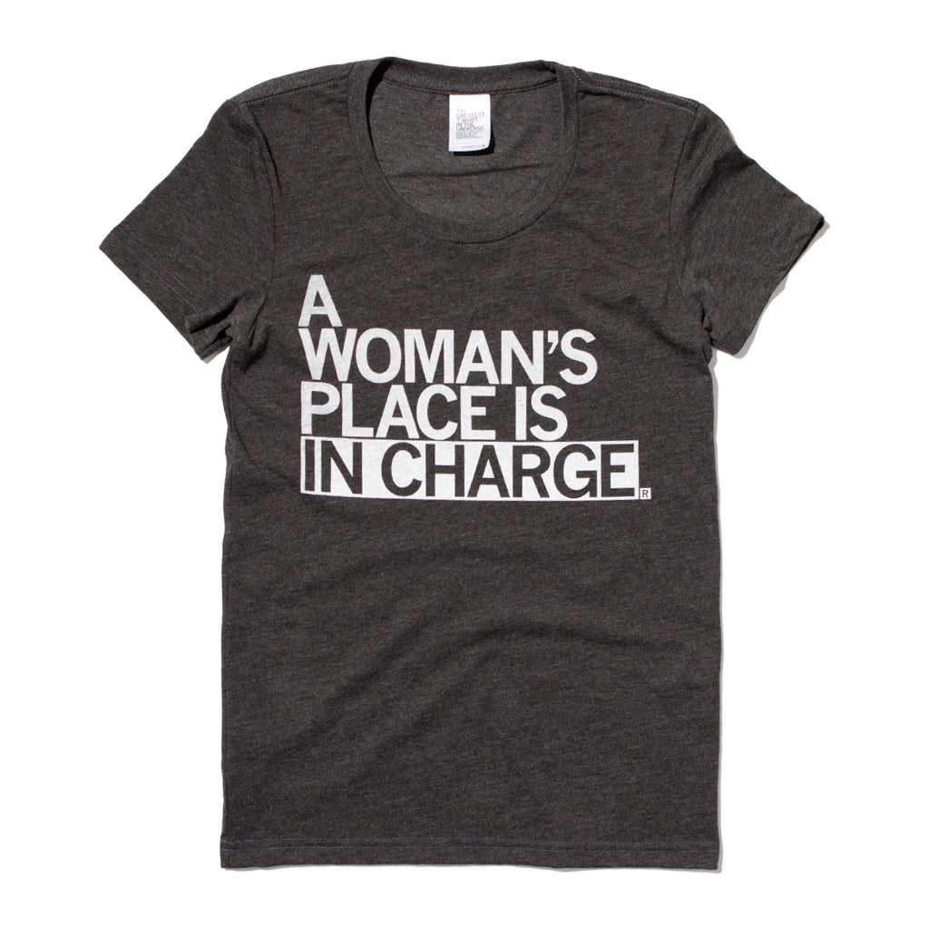 A heather charcoal shirt in a women's cut that reads "A Woman's Place Is In Charge" in all caps white text.